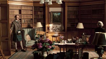 Movie still from “The Queen” (2006), directed by Stephen Frears – A living room filled with lots of books on a bookshelf; Wide shot, High angle