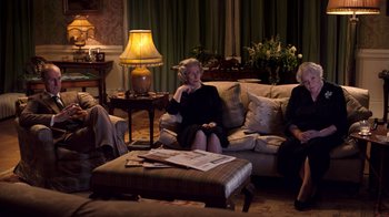 Movie still from “The Queen” (2006), directed by Stephen Frears – A group of people sitting on a couch in a living room; Wide shot, High angle