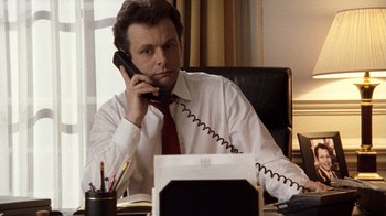 Movie still from “The Queen” (2006), directed by Stephen Frears – A man sitting at a desk talking on the phone; Close Up shot, Low angle