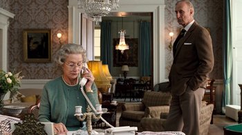 Movie still from “The Queen” (2006), directed by Stephen Frears – An older woman talking on the phone while a man watches; Medium shot, Low angle