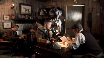 Movie still from “The Queen” (2006), directed by Stephen Frears – A group of men sitting at a table with papers; Medium shot, Low angle