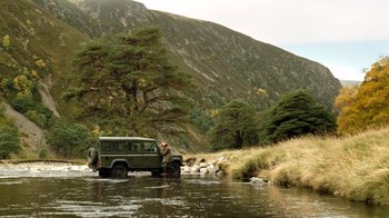 Movie still from “The Queen” (2006), directed by Stephen Frears – A man standing next to a truck in a river; Extreme Wide shot, High angle