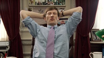 Movie still from “The Queen” (2006), directed by Stephen Frears – A man in a blue dress shirt and a purple neck tie; Medium shot, Low angle