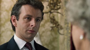 Movie still from “The Queen” (2006), directed by Stephen Frears – A person wearing a suit and tie; Close Up shot, Over the shoulder angle