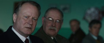 Movie still from “The Railway Man” (2013), directed by Jonathan Teplitzky – A group of men standing next to each other in front of a wall; Close Up shot, Over the shoulder angle