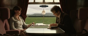 Movie still from “The Railway Man” (2013), directed by Jonathan Teplitzky – Two people sitting at a table in front of a window; Medium shot, High angle