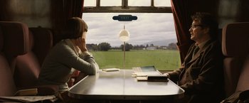 Movie still from “The Railway Man” (2013), directed by Jonathan Teplitzky – A woman sitting at a table in front of a window; Medium shot, High angle