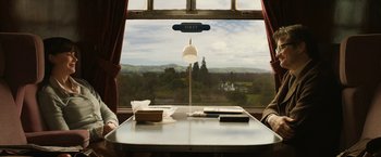 Movie still from “The Railway Man” (2013), directed by Jonathan Teplitzky – A desk with a view of a valley from a train window; Medium shot, High angle