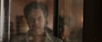 Movie still from “The Railway Man” (2013), directed by Jonathan Teplitzky – A person looking through a window; Close Up shot, Low angle
