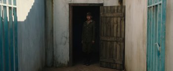 Movie still from “The Railway Man” (2013), directed by Jonathan Teplitzky – A man in uniform standing in front of an open door; Wide shot, Over the shoulder angle