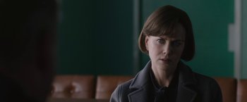 Movie still from “The Railway Man” (2013), directed by Jonathan Teplitzky – A woman in a gray coat is sitting in a room; Close Up shot, Over the shoulder angle
