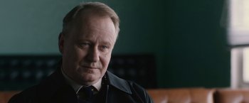Movie still from “The Railway Man” (2013), directed by Jonathan Teplitzky – An older man wearing a black jacket and a blue tie; Close Up shot, Over the shoulder angle