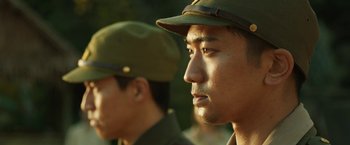 Movie still from “The Railway Man” (2013), directed by Jonathan Teplitzky – A man in a green hat is looking at the camera; Close Up shot, Low angle