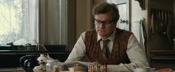Movie still from “The Railway Man” (2013), directed by Jonathan Teplitzky – A man sitting at a table reading a newspaper; Close Up shot, Low angle