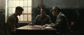 Movie still from “The Railway Man” (2013), directed by Jonathan Teplitzky – Two men sitting at a wooden table in a room; Medium shot, Over the shoulder angle