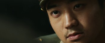 Movie still from “The Railway Man” (2013), directed by Jonathan Teplitzky – A man's face with a hat on; Extreme Close Up shot, Over the shoulder angle