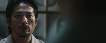 Movie still from “The Railway Man” (2013), directed by Jonathan Teplitzky – An older man is looking at the camera; Close Up shot, Over the shoulder angle