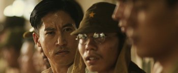 Movie still from “The Railway Man” (2013), directed by Jonathan Teplitzky – A group of people wearing glasses and hats; Close Up shot, Over the shoulder angle