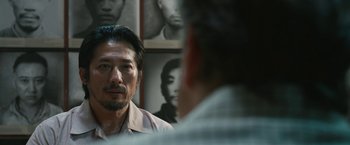 Movie still from “The Railway Man” (2013), directed by Jonathan Teplitzky – A man with a goatee is talking to another man; Close Up shot, Over the shoulder angle