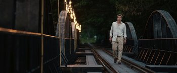 Movie still from “The Railway Man” (2013), directed by Jonathan Teplitzky – A man is walking down a train track at night; Wide shot, Low angle