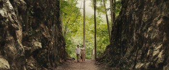 Movie still from “The Railway Man” (2013), directed by Jonathan Teplitzky – A man and a woman standing in the middle of a forest; Extreme Wide shot, Low angle