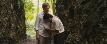 Movie still from “The Railway Man” (2013), directed by Jonathan Teplitzky – Two men standing next to each other near a tree; Medium shot, Over the shoulder angle