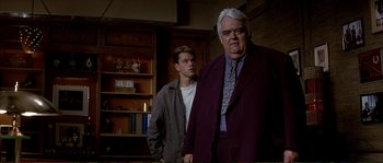 Movie still from “The Rainmaker” (1997), directed by Francis Ford Coppola – A man and a boy standing next to each other in a room; Medium shot, Low angle