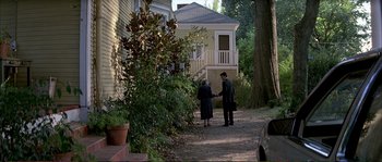 Movie still from “The Rainmaker” (1997), directed by Francis Ford Coppola – A man and a woman holding hands on a sidewalk; Wide shot, High angle