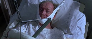 Movie still from “The Rainmaker” (1997), directed by Francis Ford Coppola – A man in a hospital bed wearing a head brace; Close Up shot, High angle