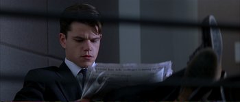 Movie still from “The Rainmaker” (1997), directed by Francis Ford Coppola – A man in a suit and tie reading a newspaper; Close Up shot, Low angle