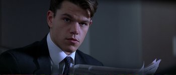 Movie still from “The Rainmaker” (1997), directed by Francis Ford Coppola – A man in a suit and tie looking at the camera; Close Up shot, Low angle