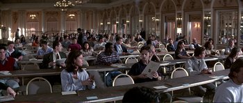 Movie still from “The Rainmaker” (1997), directed by Francis Ford Coppola – A group of people sitting at tables in a room; Wide shot, High angle