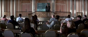 Movie still from “The Rainmaker” (1997), directed by Francis Ford Coppola – A group of people sitting in a room with chairs; Wide shot, High angle