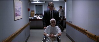 Movie still from “The Rainmaker” (1997), directed by Francis Ford Coppola – A man standing next to a woman in a wheel chair; Medium shot, Over the shoulder angle