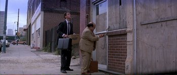 Movie still from “The Rainmaker” (1997), directed by Francis Ford Coppola – Two men in business suits are standing by a door; Wide shot, Low angle