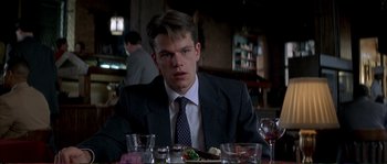 Movie still from “The Rainmaker” (1997), directed by Francis Ford Coppola – A man sitting at a table with a plate of food in front of him; Close Up shot, Low angle