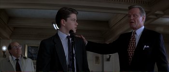 Movie still from “The Rainmaker” (1997), directed by Francis Ford Coppola – A man in a black suit and a man in a black suit; Medium shot, Low angle