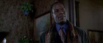 Movie still from “The Rainmaker” (1997), directed by Francis Ford Coppola – A man in a suit and tie with a scarf around his neck; Close Up shot, Low angle