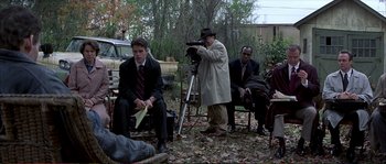 Movie still from “The Rainmaker” (1997), directed by Francis Ford Coppola – A group of men sitting around a field; Wide shot, High angle