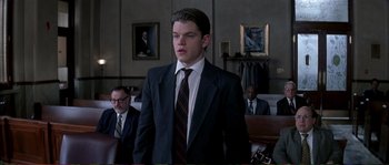 Movie still from “The Rainmaker” (1997), directed by Francis Ford Coppola – A man wearing a suit and tie in a courtroom; Medium shot, Low angle