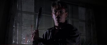 Movie still from “The Rainmaker” (1997), directed by Francis Ford Coppola – A young man holding a baseball bat in a dark room; Close Up shot, Low angle