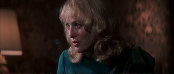 Movie still from “The Rainmaker” (1997), directed by Francis Ford Coppola – A woman with blonde curly hair wearing a blue shirt; Close Up shot, Over the shoulder angle