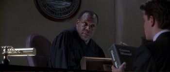 Movie still from “The Rainmaker” (1997), directed by Francis Ford Coppola – A man wearing a robe sitting in a courtroom; Close Up shot, Low angle