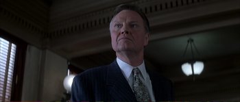 Movie still from “The Rainmaker” (1997), directed by Francis Ford Coppola – A man in a suit and tie looking upward; Close Up shot, Low angle
