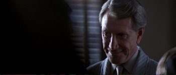 Movie still from “The Rainmaker” (1997), directed by Francis Ford Coppola – A person wearing a suit and tie; Close Up shot, Over the shoulder angle