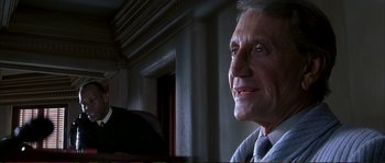 Movie still from “The Rainmaker” (1997), directed by Francis Ford Coppola – An older man is smiling for the camera; Close Up shot, Low angle