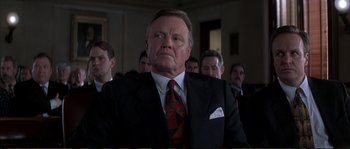 Movie still from “The Rainmaker” (1997), directed by Francis Ford Coppola – An older man in a suit and tie looking up; Close Up shot, Low angle