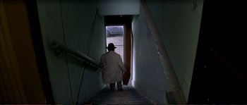 Movie still from “The Rainmaker” (1997), directed by Francis Ford Coppola – A man in a trench coat walking down a staircase; Wide shot, High angle