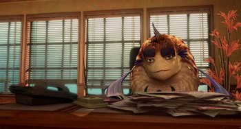 Movie still from “Shark Tale” (2004), directed by Vicky Jenson – An image of an animated creature sitting at a desk; Medium shot, High angle
