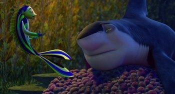 Movie still from “Shark Tale” (2004), directed by Vicky Jenson – An animated shark is eating a bunch of fish; Medium shot, Over the shoulder angle